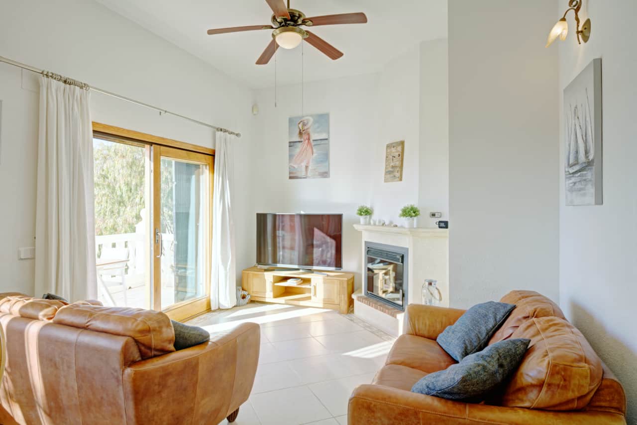 Gemütlicher Wohnbereich mit Ledersofas und Smart-TV