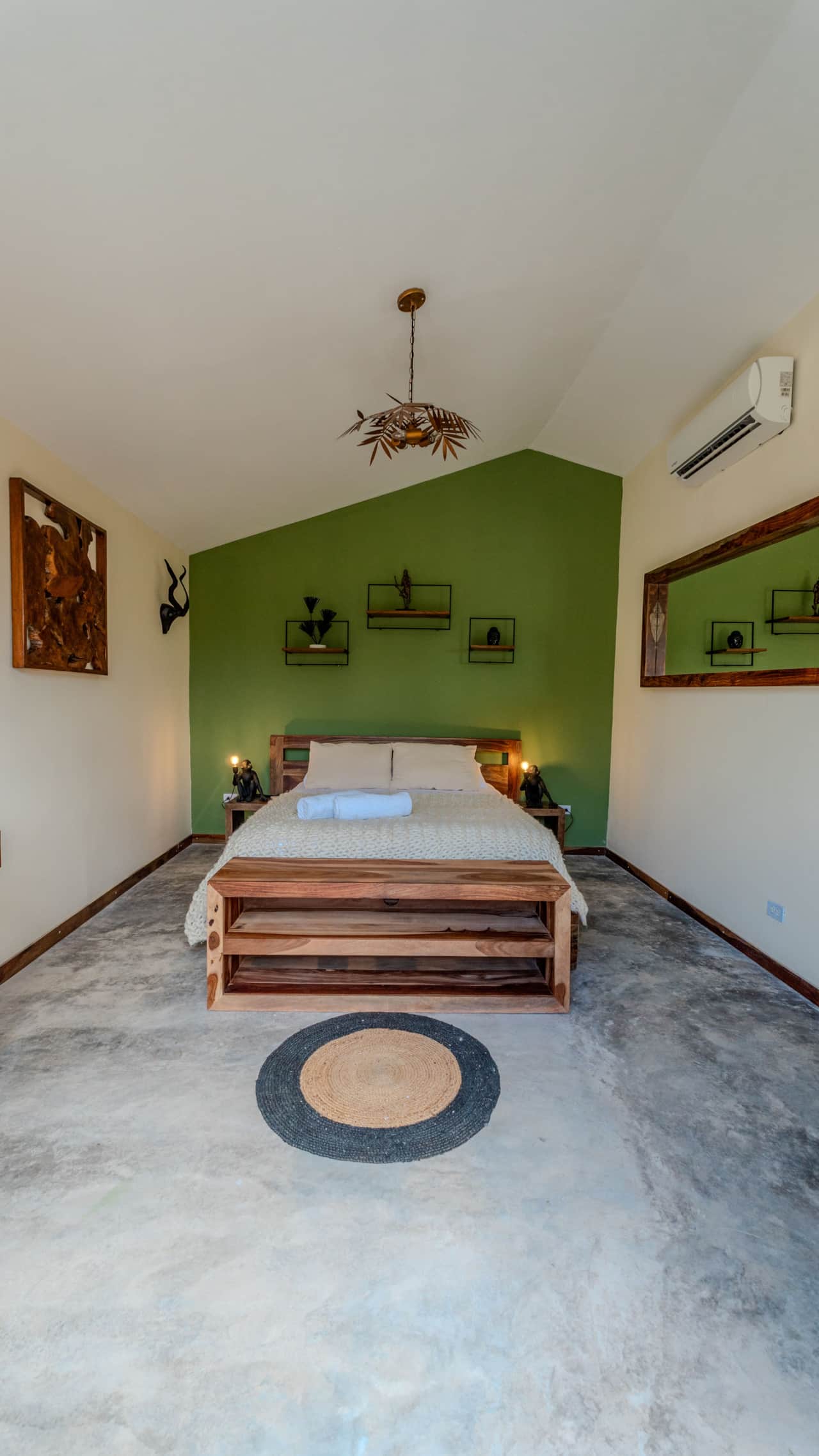 Airy eco-cabin bedroom with vaulted ceiling and green feature wall in Coronado, Panama