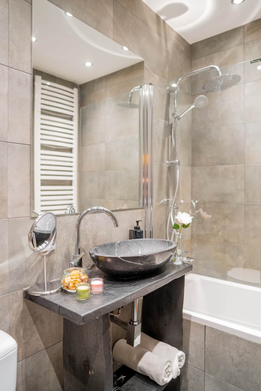 Nowoczesna, jasna łazienka z prysznicem i funkcjonalnym blatem z umywalką.