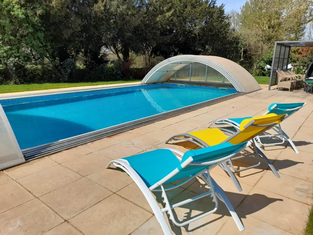Pool retractable safety cover and sun protection pergola.