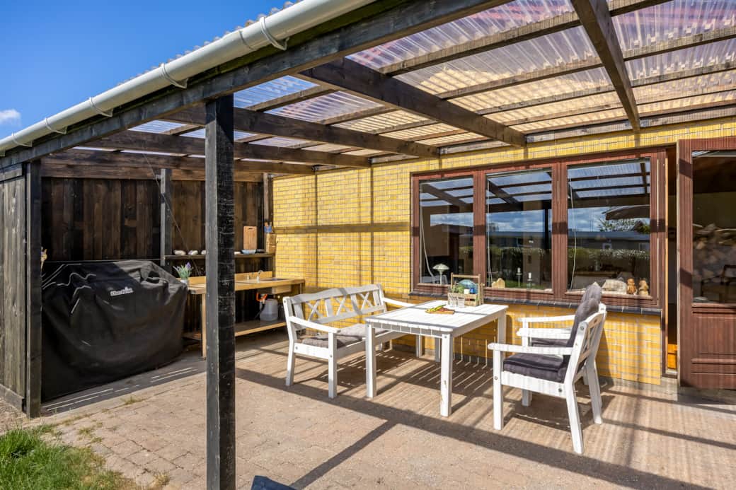 Overdækket terrasse med spiseplads og udendørs køkken med gasgrill Overdækket terrasse med spiseplads og udendørs køkken med gasgrill