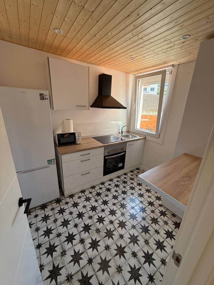 Cocina abierta con horno, campana y suelo hidráulico
