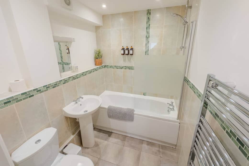 Master bathroom with bathtub, shower, toilet, wash basin, shampoo etc