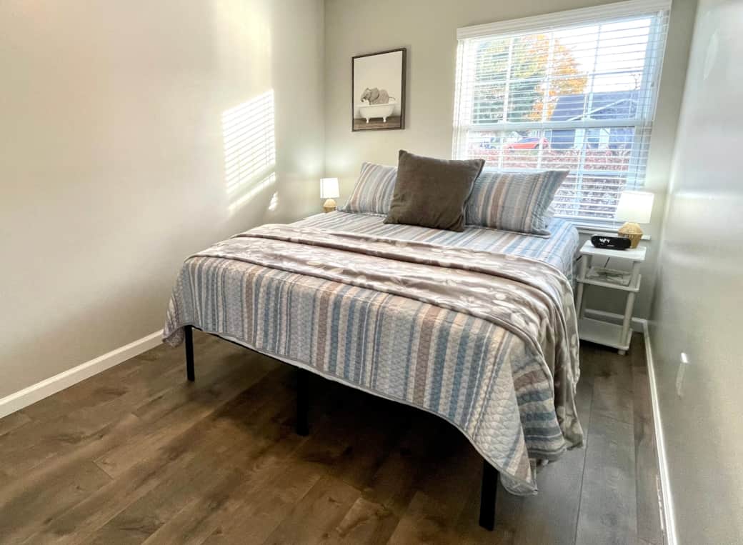 Comfortable queen-size bed with side tables and an alarm clock for a restful night’s sleep.