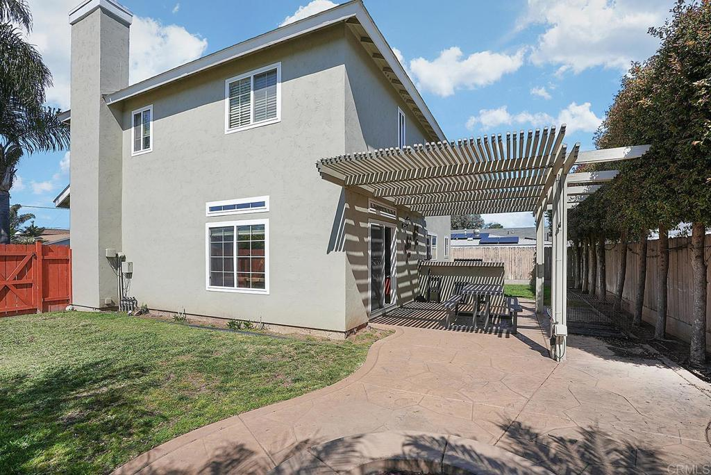 Relax outdoors beneath the shaded pergola overlooking the landscaped backyard.