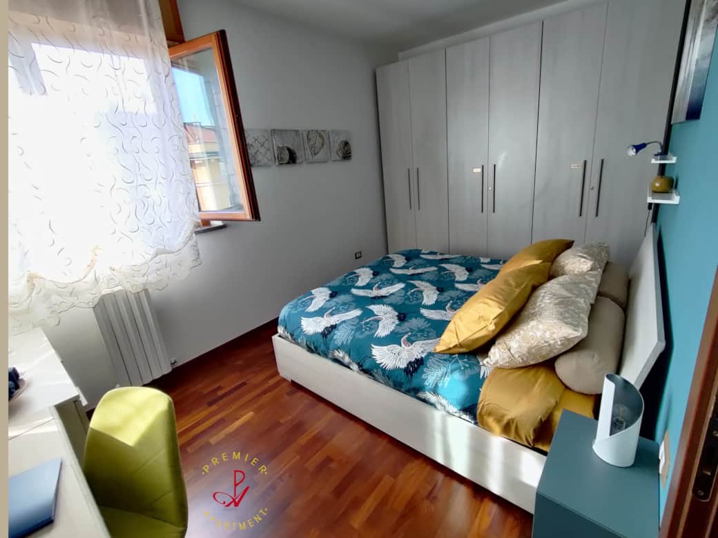 Bright bedroom with parquet flooring, desk, chest of drawers and wardrobe