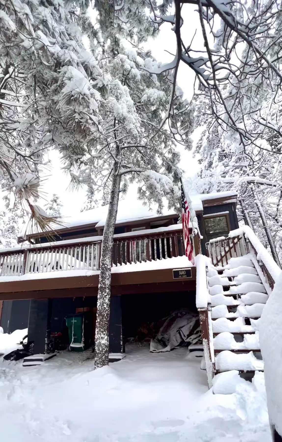 Snow-covered front deck of Munds Park cabin in winter
