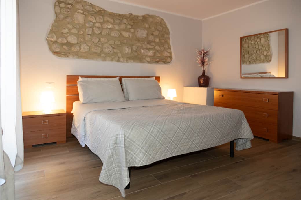 Camera matrimoniale con parete in pietra Camera matrimoniale con parete in pietra