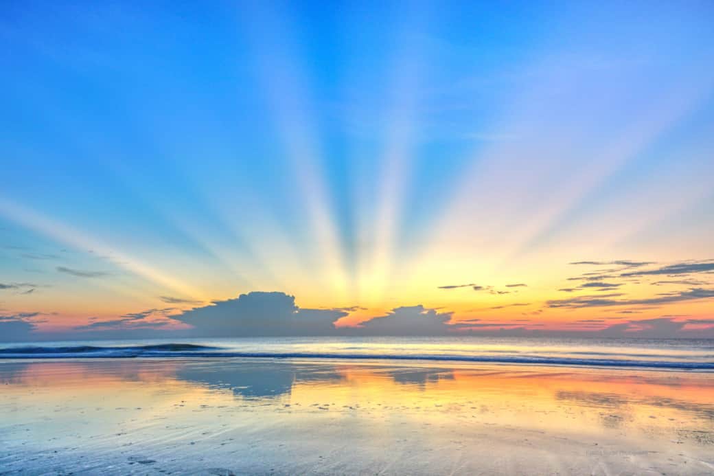 Sunrise over calm ocean by Katrina Baxter