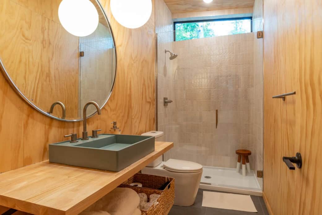 Experience a shower amongst the trees in our modern bathroom. Bathroom features a turquoise Concretti sink and plush, fluffy white cotton towels for a spa-like feel during your stay.