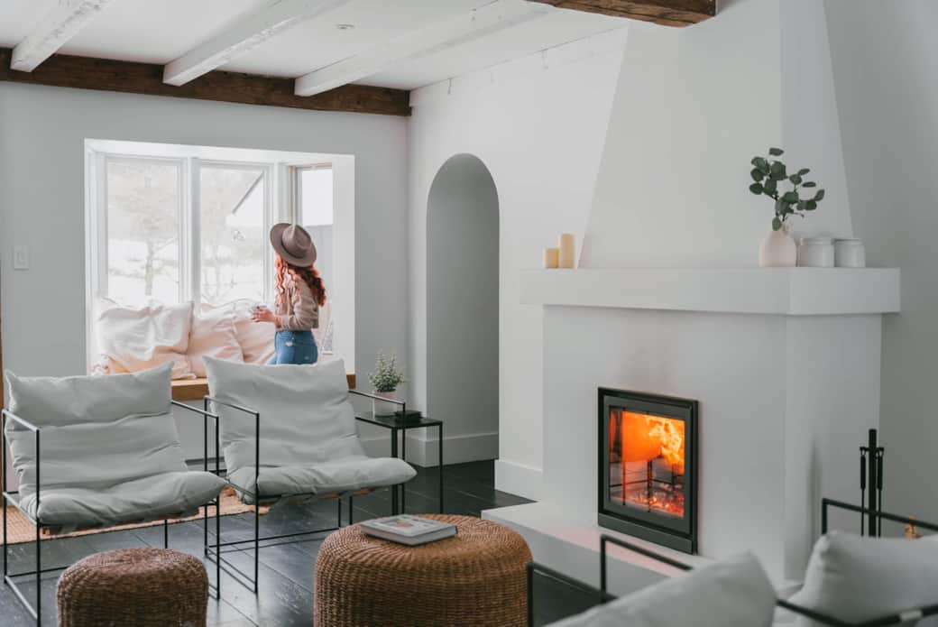 Comfortable chairs facing the wood-burning fireplace.