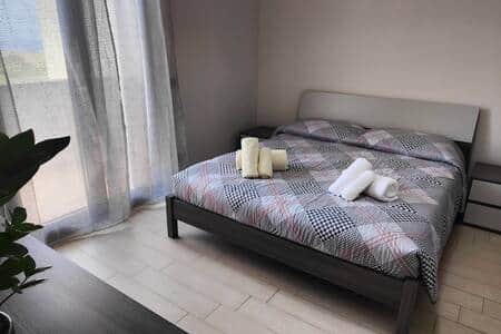 Master bedroom with queen size bed, chest of drawers, wardrobe, and a beautiful balcony