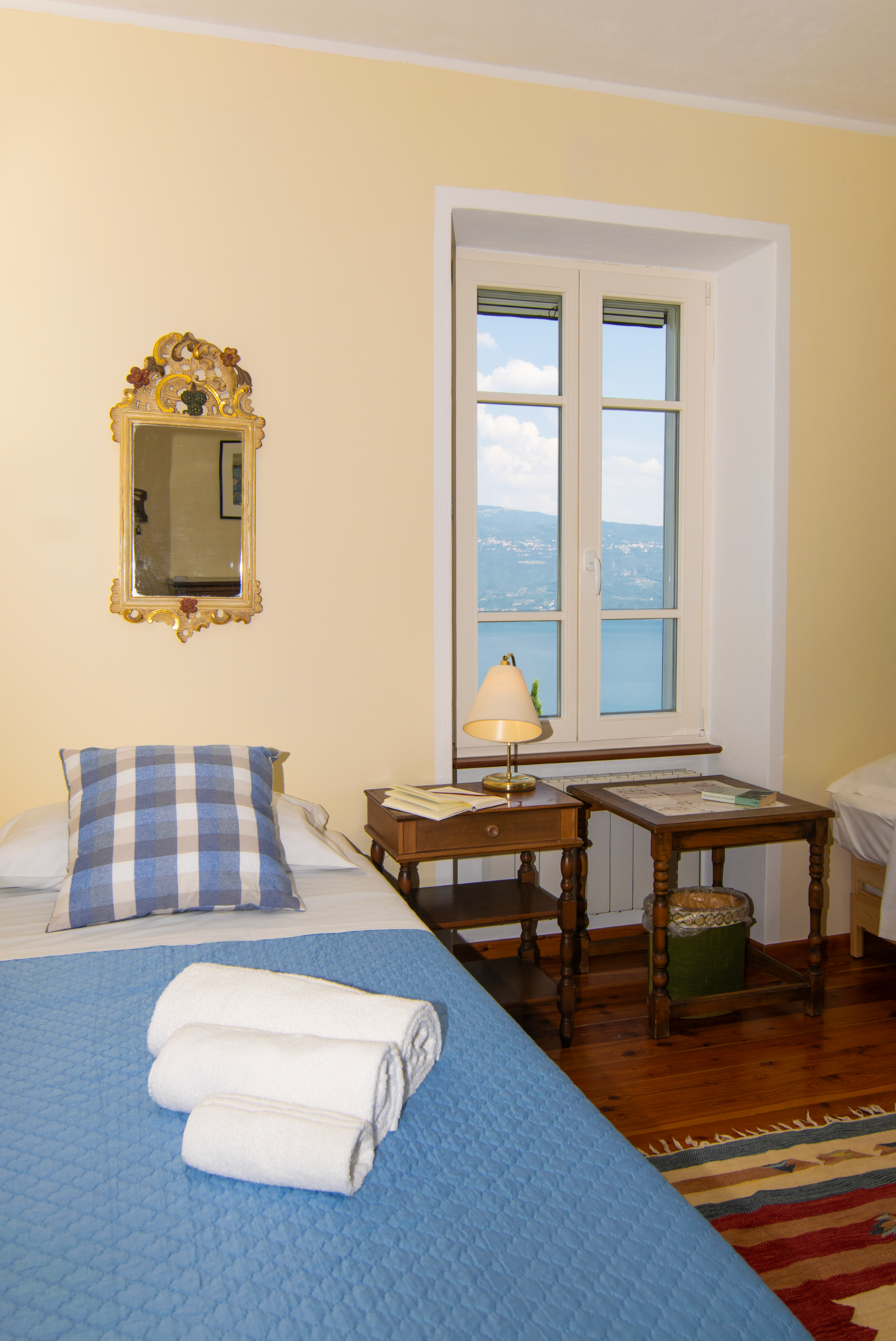 Twin bedroom with desk, natural light, and lake view for villa stays on Lake Garda.