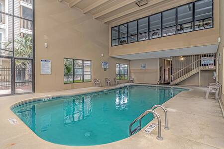 glass-enclosed indoor pool that features an incredible view of the beach