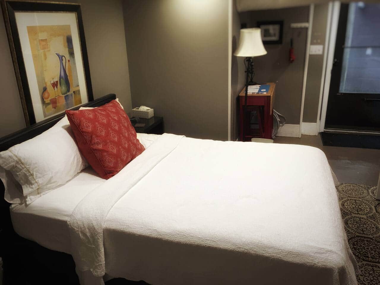 You can see the screen door in the background if it is nice outside you can open the solid door to reveal the screen door. 
What is that red table with the lamp? It converts into a desk with stools for work!
The floors are painted concrete. The ceilings a