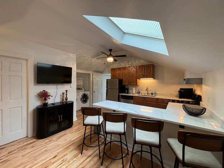 Bright loft-style kitchen with a skylight, spacious island seating, and modern appliances. 