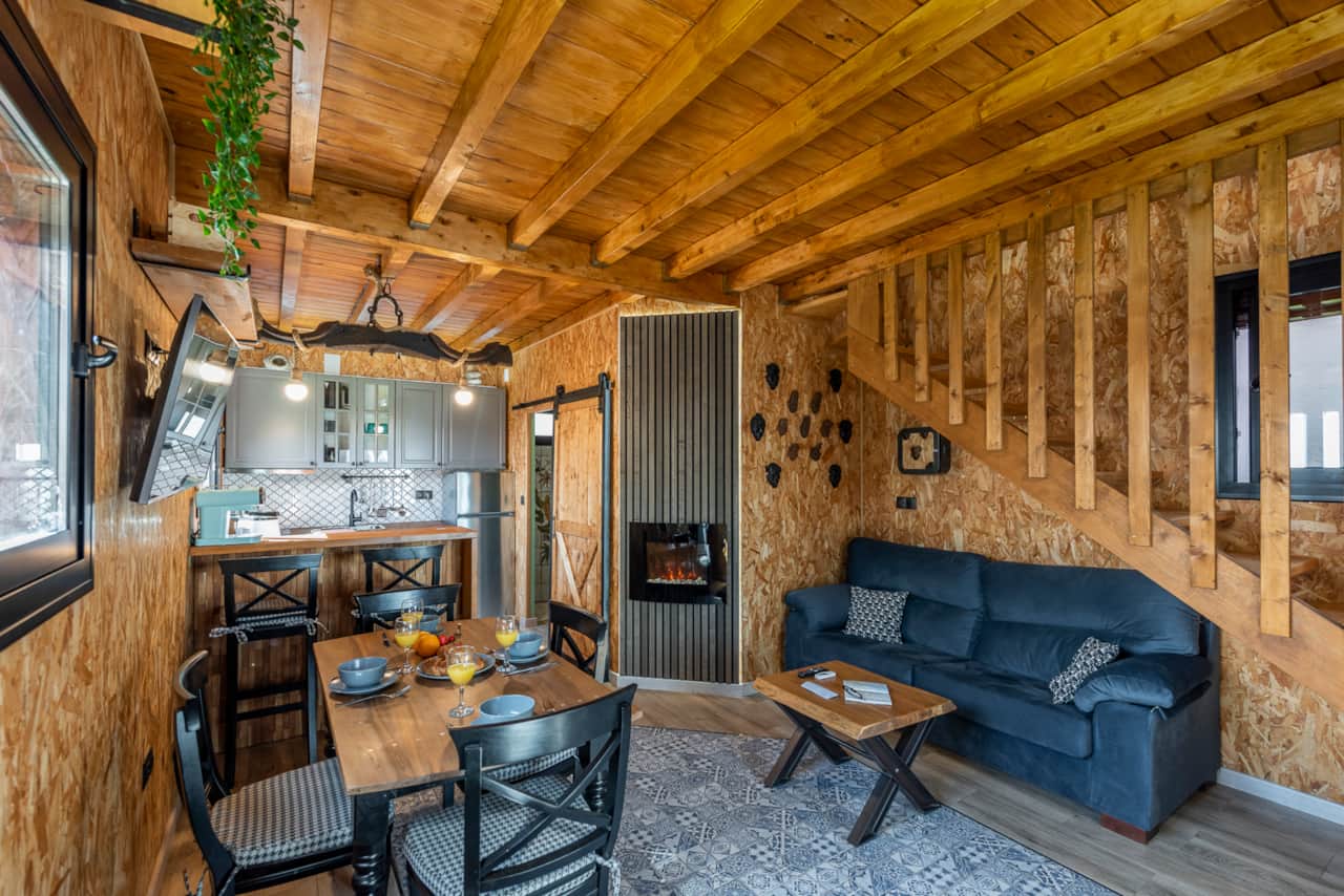 Salón y cocina en casita de madera. Para más de 8 plazas. Con Smart TV, chimenea eléctrica, sofá