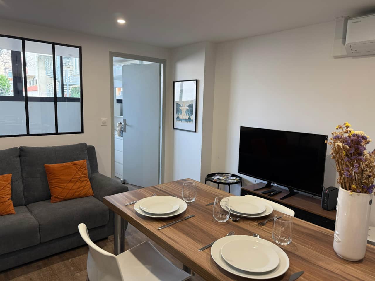 living room, dining room, dining table, sofa, microwave, television, kitchen, coffee maker