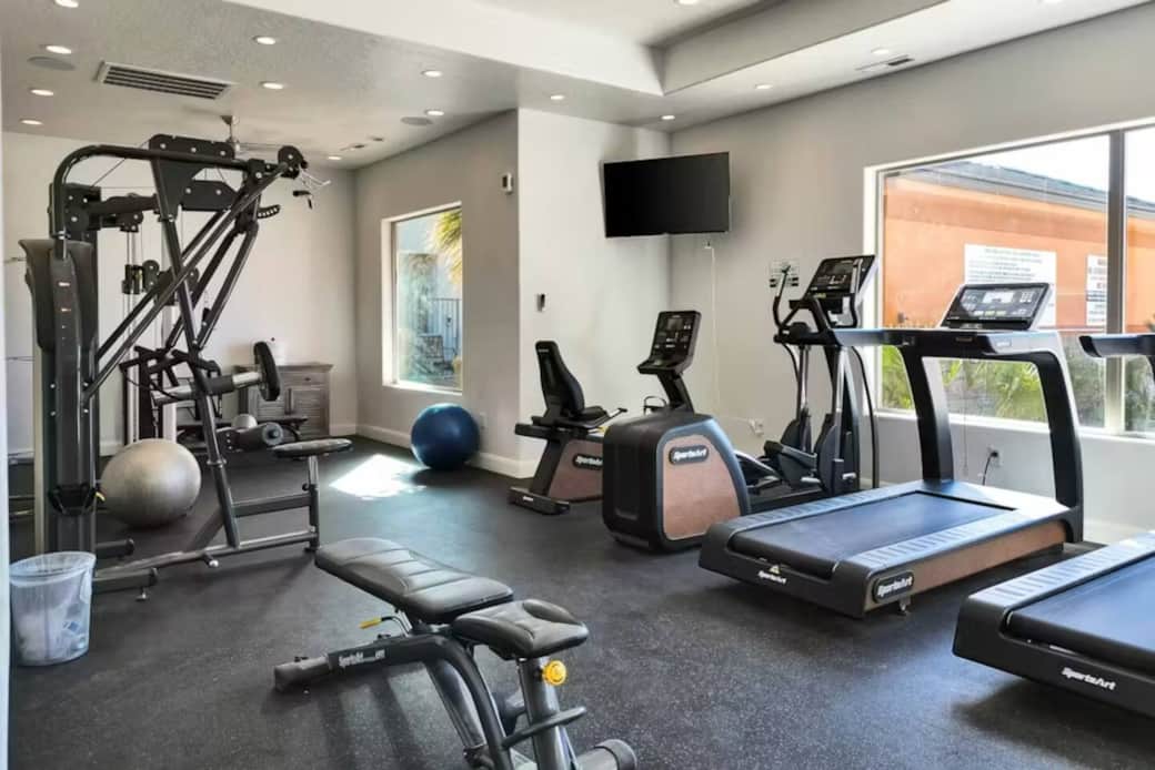 Fitness center is well equipped with trend mills, exercise machines and weights, while watching TV Fitness center is well equipped with trend mills, exercise machines and weights, while watching TV