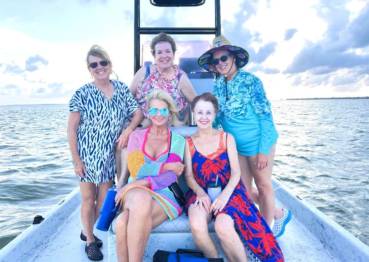 Group of friends enjoying a boat ride in Galveston Bay at sunset