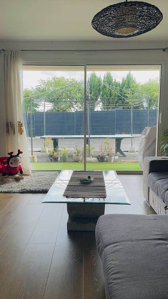 Salon ouvert et lumineux, avec vue sur la terrasse.