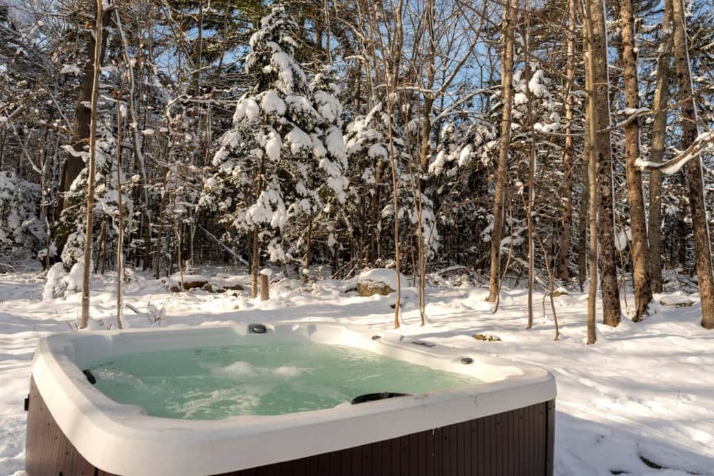 Our beautiful and year round outdoor area surrounded by the trees. Enjoy the hot tub, lawn games, & propane fire pit!