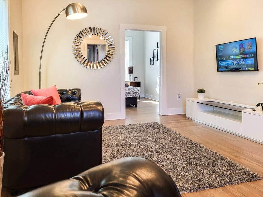 Stylish living area with comfy leather couch seating and Smart TV