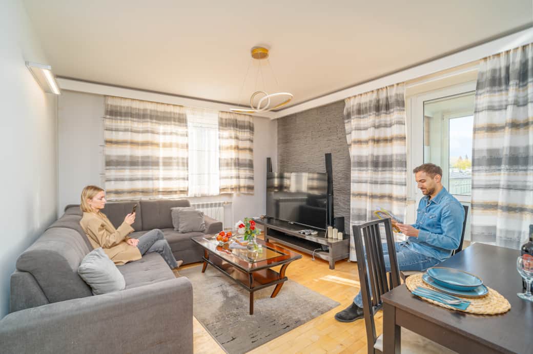 Przytulny salon z wygodnymi sofami, stolikiem kawowym i telewizorem.