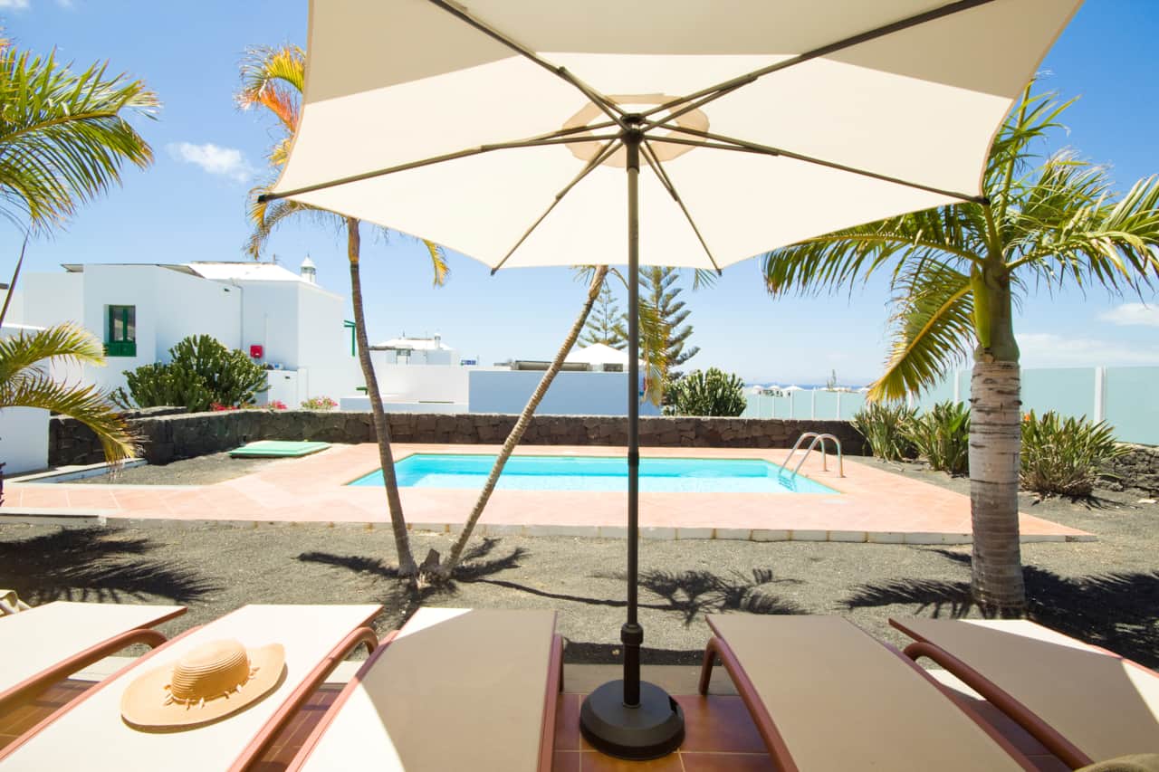 Terraza soleada con zona de descanso y vistas a la piscina en Villa Costa Papagayo 11