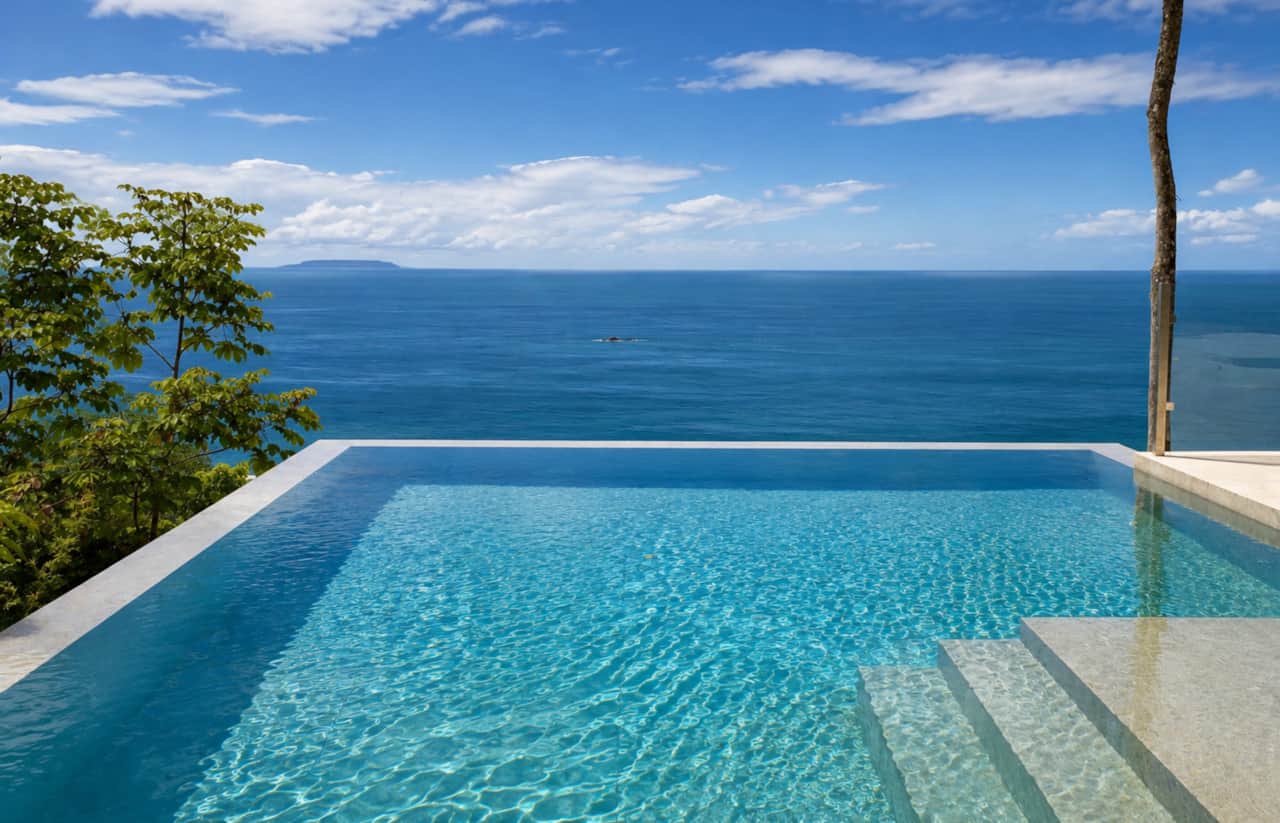 Crystal-clear infinity pool framed by jungle and uninterrupted Pacific Ocean views.