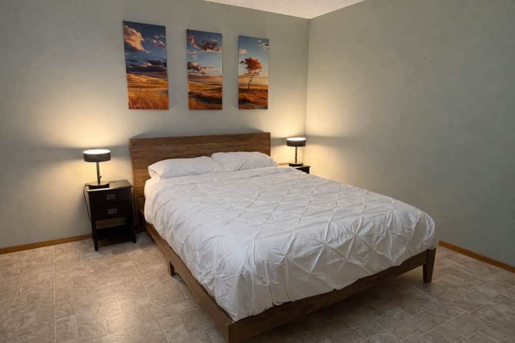 Spacious master bedroom with queen bed and warm lighting