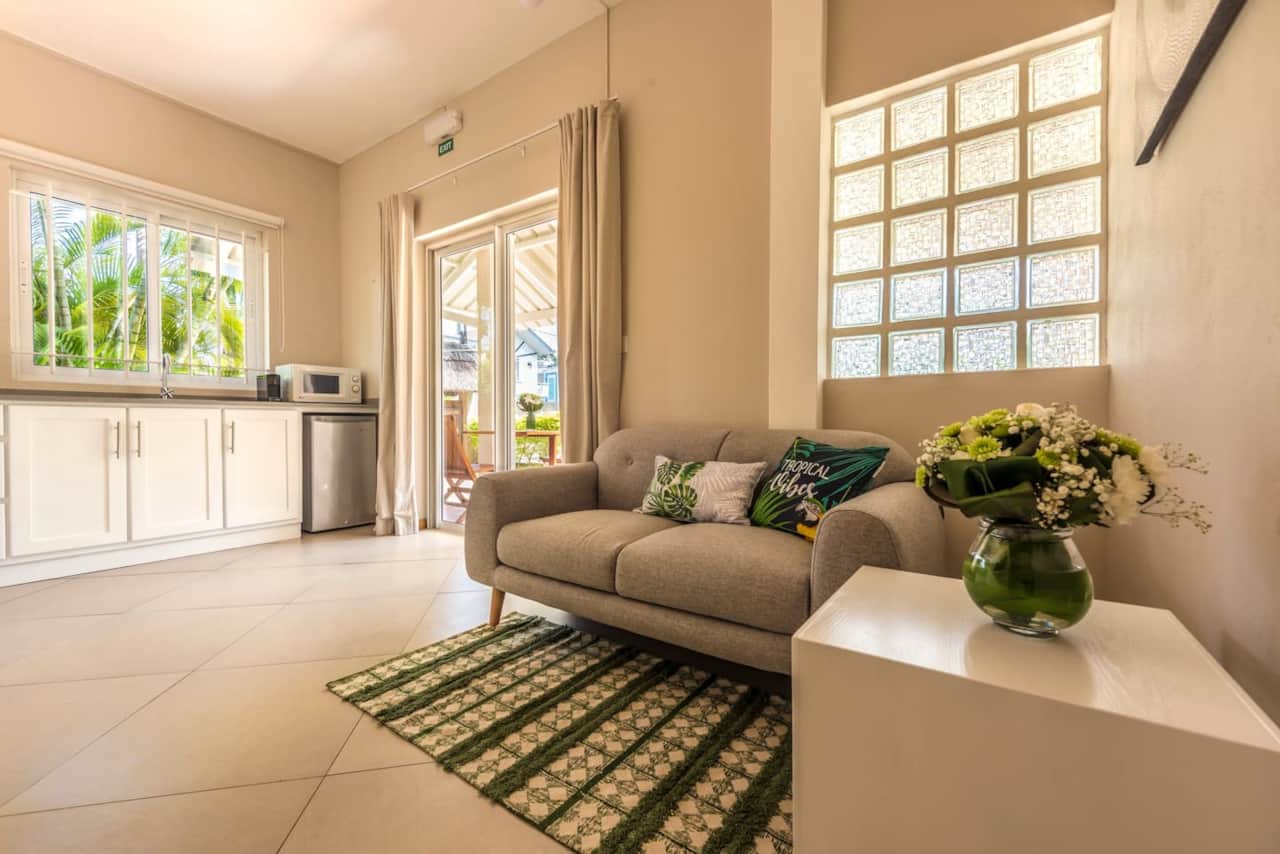 Small living area with Kitchen overlooking the terrace and garden with shared pool