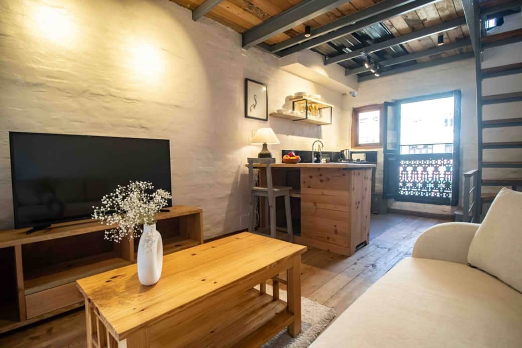 Living room with sofa and TV and open kitchennette