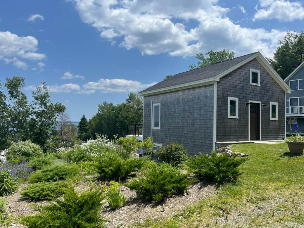 Charming Ferry House with cedar shake siding, vibrant planters, set in serene Lincolnville Beach.