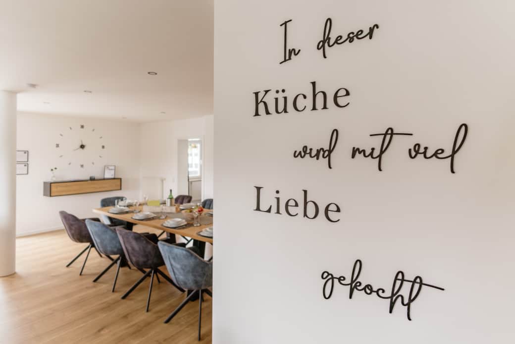 Essbereich mit großem Tisch und 10 Stühlen. Servietten, Salz, Pfeffer.