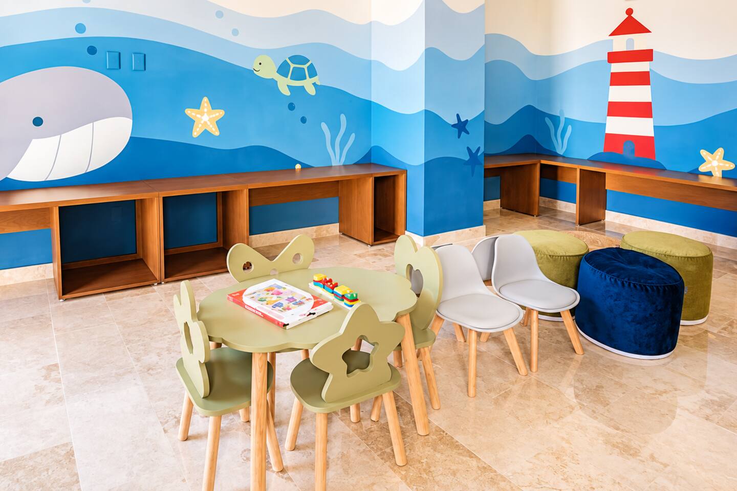 El centro de actividades infantiles, junto al salón de juegos, ofrece un espacio divertido y colorido con mesas y sillas para niños, libros y actividades para que los más pequeños disfruten su estancia.
