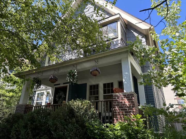 Charming home with a welcoming covered porch surrounded by lush greenery.