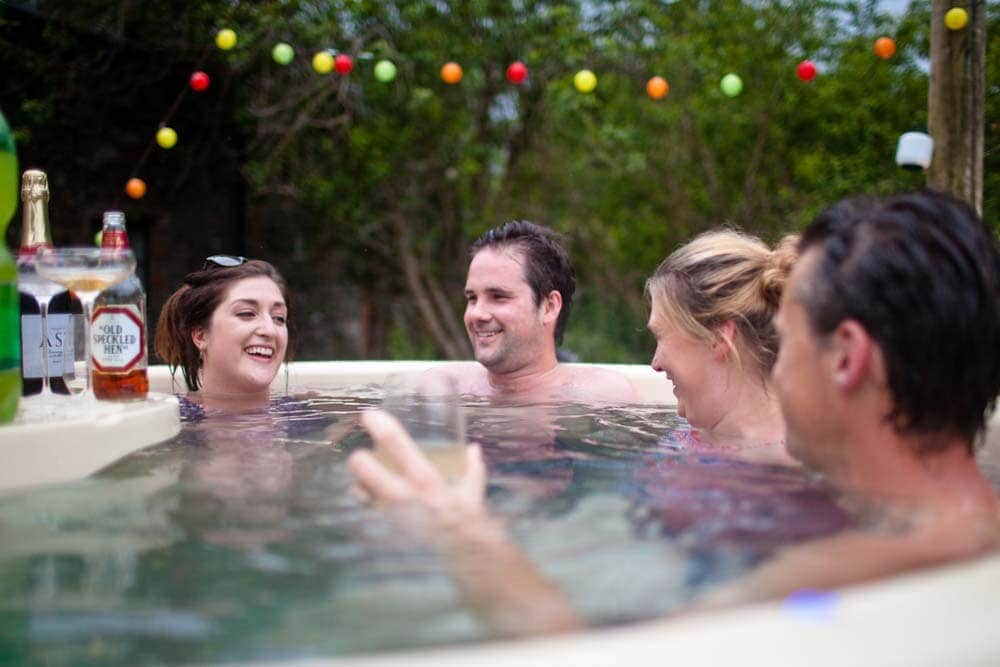 Guests relaxing together in the private wood-fired hot tub
