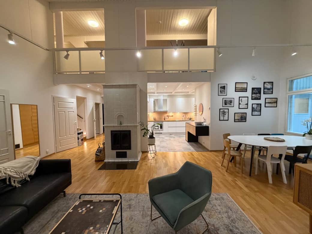 Open plan living with extra high ceilings - lounge and front view of the full kitchen.