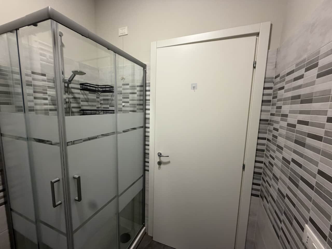 Ducha con azulejos en tiras y puerta de cristal