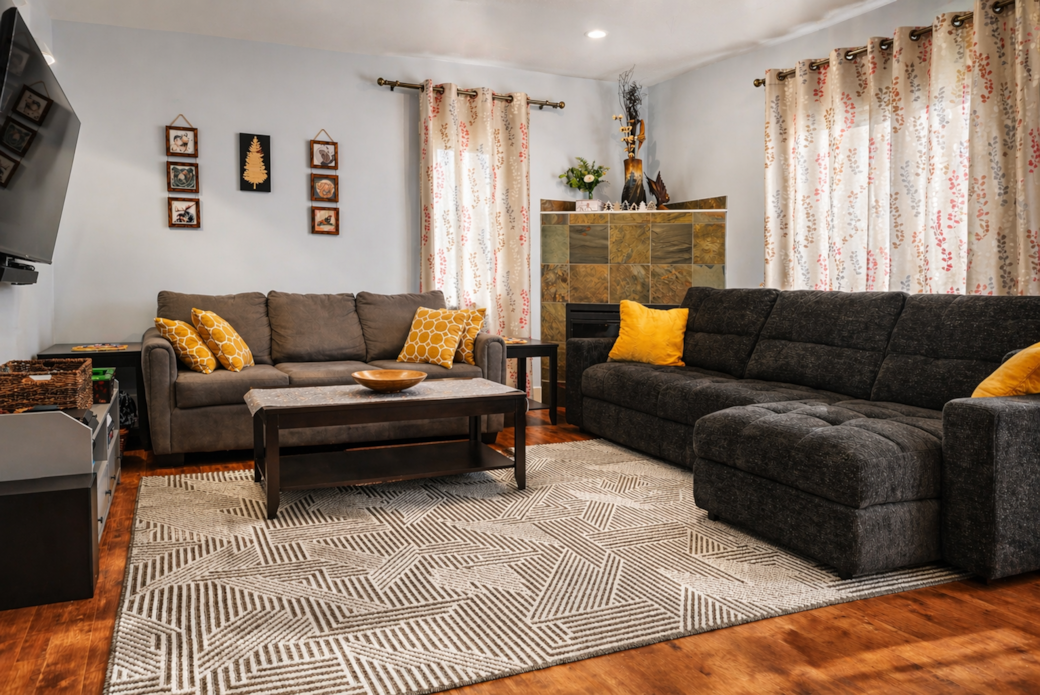 Large cozy reclining sectional next to an electric fireplace.