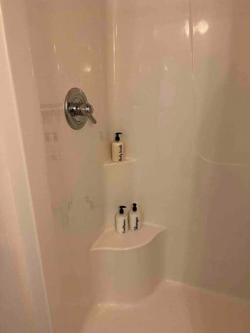  The bathroom is equipped with shampoo, conditioner, facial wipes, and body wash.