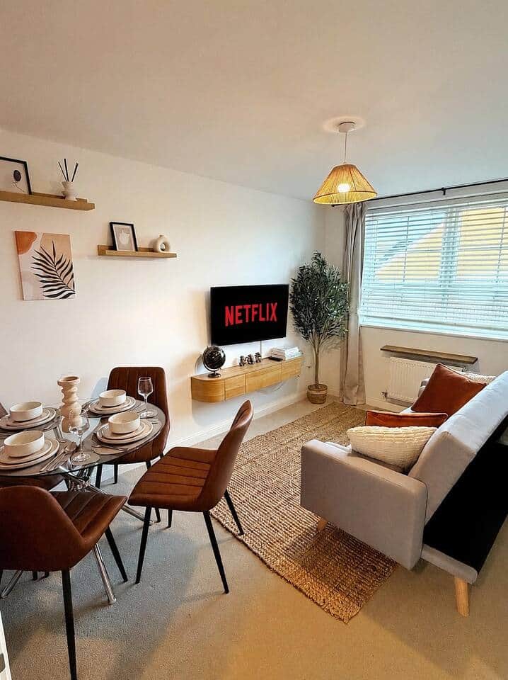 Unwind in this thoughtfully styled open-plan living and dining area, featuring a comfortable sofa, Smart TV with Netflix, and large windows that fill the room with natural light