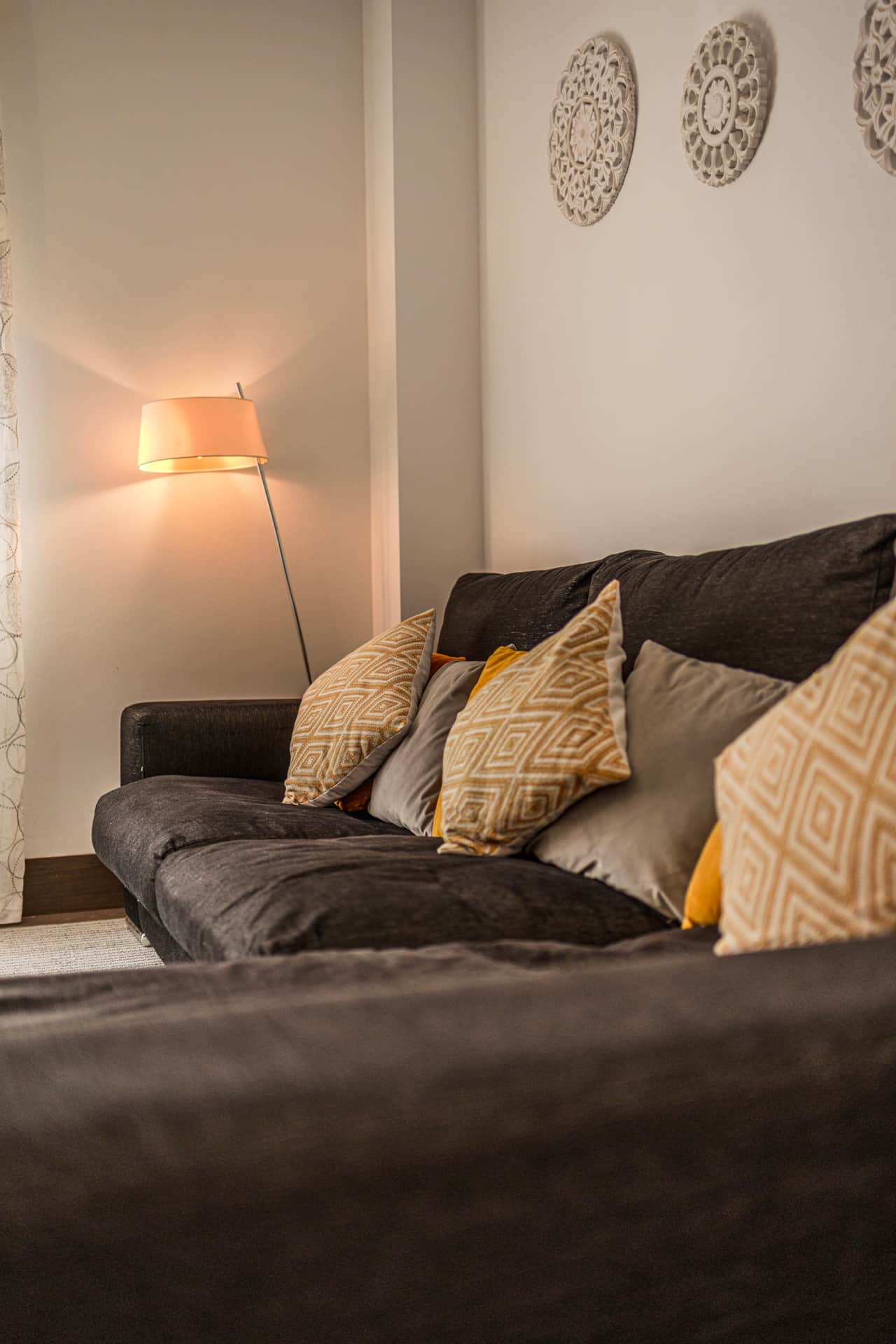 Salón con sofá cama y lámpara de pie
