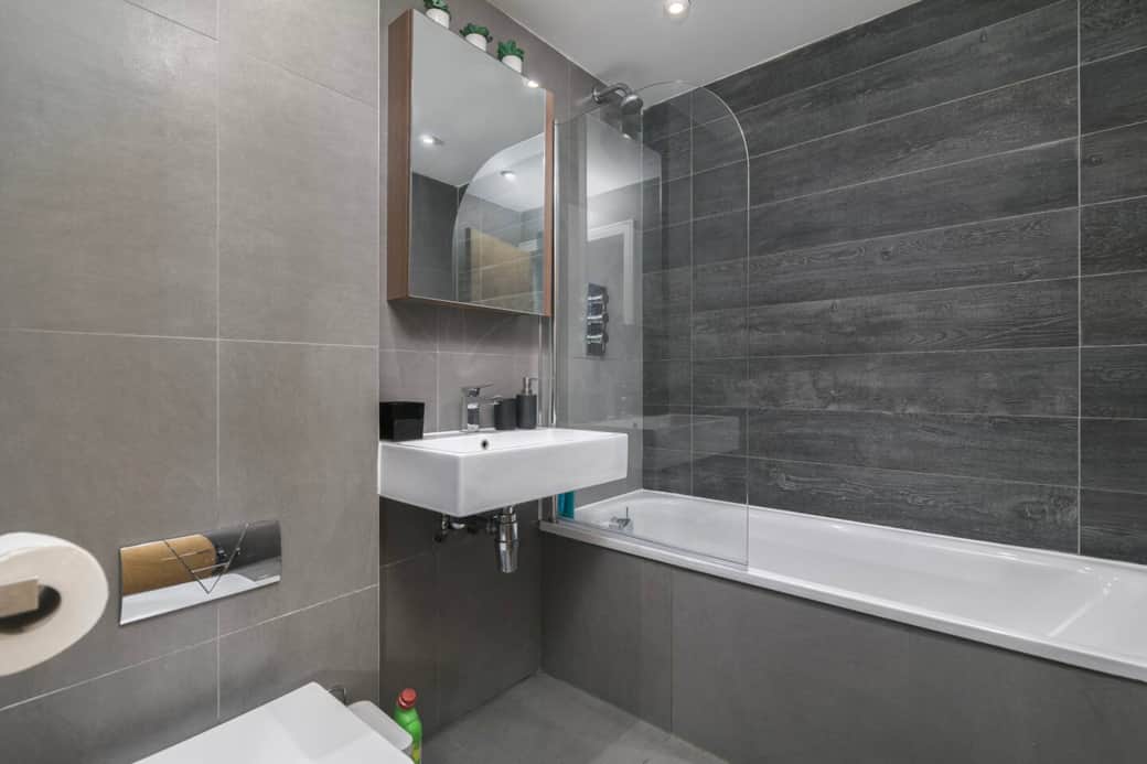 Enjoy a refreshing shower or a relaxing bath in this modern bathroom, thoughtfully designed with contemporary finishes and practical storage space. Enjoy a refreshing shower or a relaxing bath in this modern bathroom, thoughtfully designed with contemporary finishes and practical storage space.