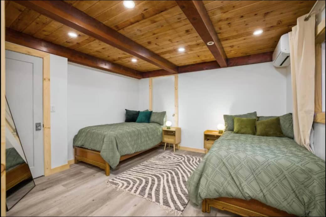 Warm, wood-accented bedroom featuring two inviting beds and a peaceful retreat for a restful night’s sleep.