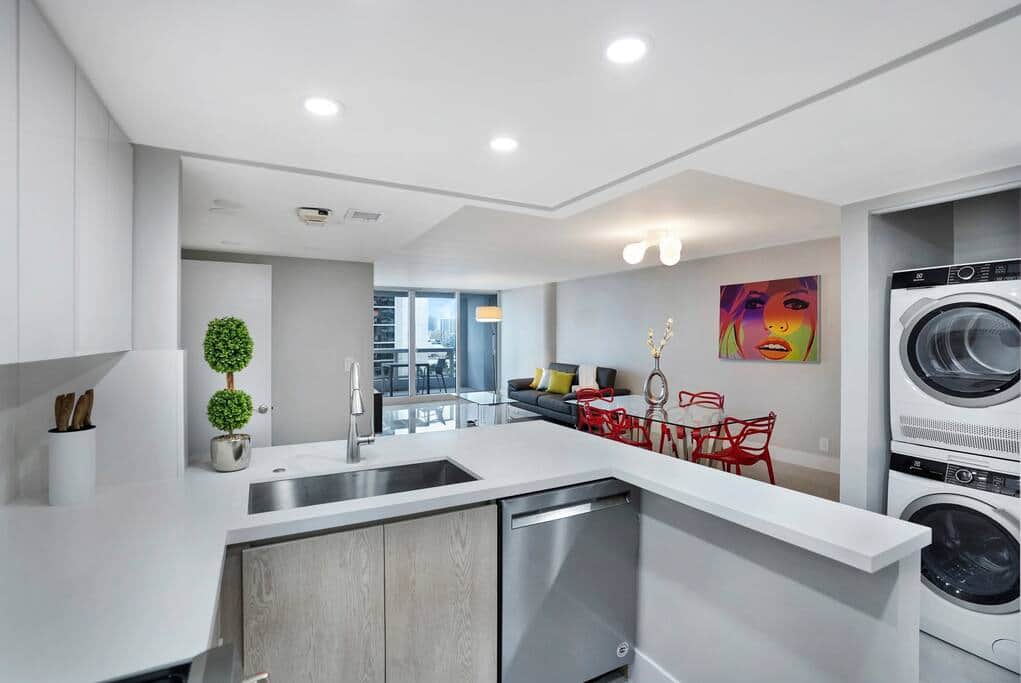 Fully equipped kitchen, washer/dryer, view into living/dining area