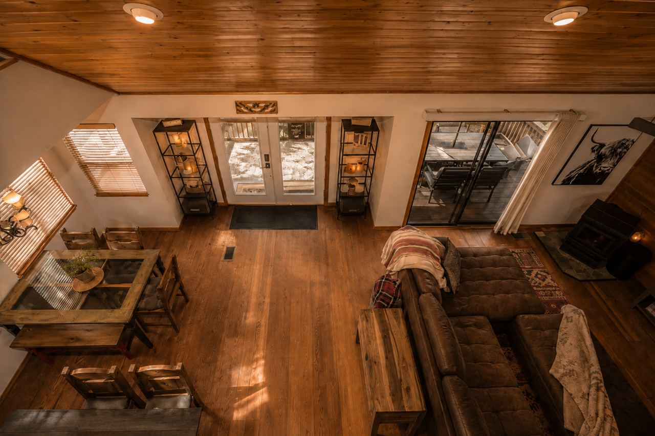 Open living, dining, and deck view from loft inside cabin