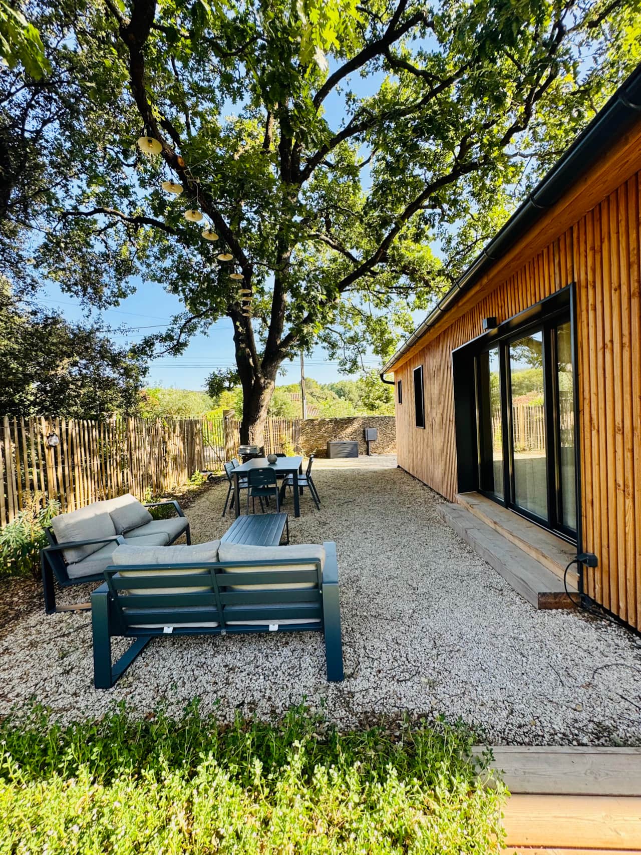 Terrasse privative ombragée sous un majestueux arbre pour vos repas en plein air