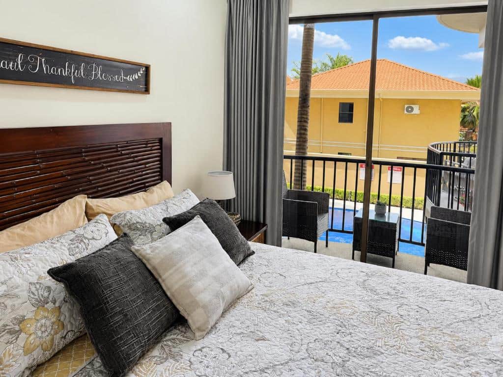 Cozy bedroom with queen bed, balcony, and pool view | Monaco Condominiums Jaco, Costa Rica Cozy bedroom with queen bed, balcony, and pool view | Monaco Condominiums Jaco, Costa Rica